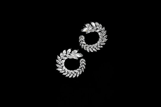 Round Silver earrings with jewels on the black background. Fashion