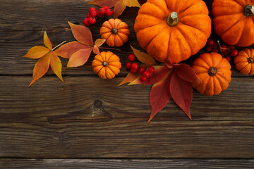 Framework with pumpkins and fall leaves on wooden background. Top view.