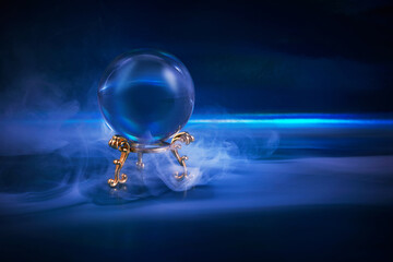 Crystal ball in a dark blue smoky background. Guessing for the future.