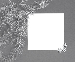 Christmas mockup with silver snowflakes and tinsel on grey background. Copy space, top view, flat lay.