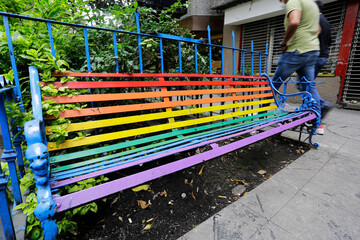 A bench is seen painted with the rainbow colors in a street of Pink zone, zona rosa neighborhood, Mexico City, Mexico. - obrazy, fototapety, plakaty