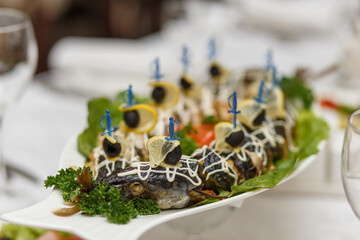 A stuffed pike with vegetables on the table