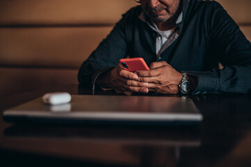 Senior hispanic cuban men using smartphone while working remotely in a cafe