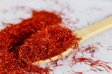 Indian saffron dried spice on wooden spoon.