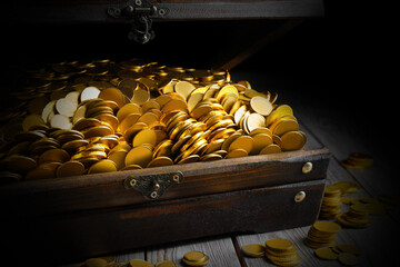 Open treasure chest with gold coins on grey wooden table, closeup © New Africa