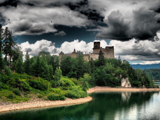 mroczny zamek na wzniesieniu otoczony przez ciemne chmury