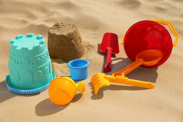 Fototapeta na wymiar Set of plastic beach toys on sand. Outdoor play
