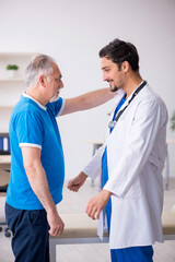 Fototapeta premium Old male patient visiting young male doctor