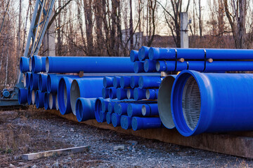Stack of cast iron pipes in loading area waiting for transportation