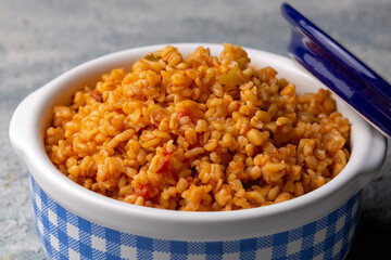 Traditional turkish bulgur pilaf with tomato sause in plate (Turkish name; meyhane pilavi)