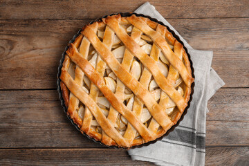 Delicious traditional apple pie on wooden table, top view