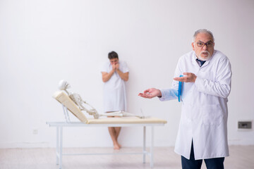 Obraz premium Old male doctor psychiatrist examining young male patient