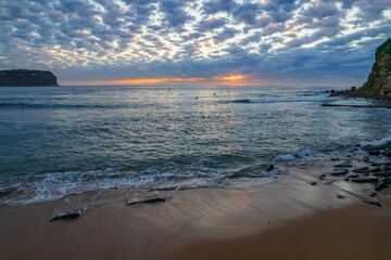Aerial sunrise seascape with cloud covered sky from MacMasters Beach on the Central Coast, NSW, Australia.