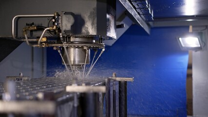 The machine at the factory drills a part with water supply. Metal production processing. Spindle...