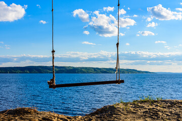 Empty swing hanging from the tree at bank of river Dnieper