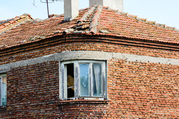 Window in red brick wall of the ancient residential building