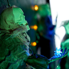 Halloween decoration garland of glowing spiders on the arm of a skeleton