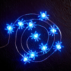 Halloween decoration garland of glowing spiders laid out in a spiral