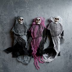 Halloween decoration three toy skeletons in colorful capes