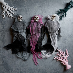 Halloween decoration three toy skeletons in colorful capes