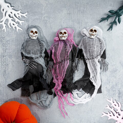Halloween decoration three toy skeletons in colorful capes