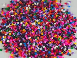 Fototapeta na wymiar Kupka kolorowych koralików rozsypana na stole