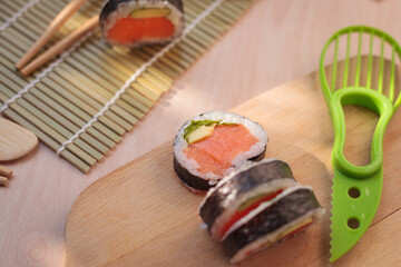 Closeup of sushi with chopsticks on a wooden background
