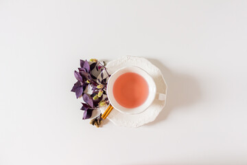 Fototapeta na wymiar Cup of ginger tea composition with purple, pink on white background. Flat lay, top view. 