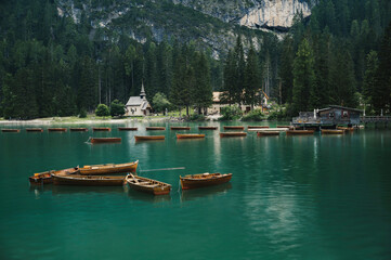 Lago di Braies (Braies lake, Pragser wildsee) wooden boats in Lake in South Tyrol, Italy ; moody evening (high ISO photography)