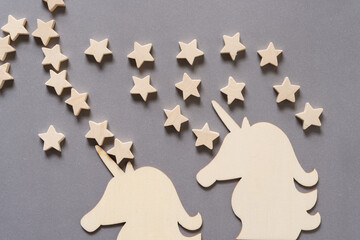 Fototapeta premium two wooden unicorn shapes or silhouettes arranged on gray paper