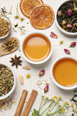 Flat lay composition with fresh brewed tea and dry leaves on white wooden table