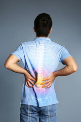 Man having backache on grey background. Digital compositing with illustration of spine