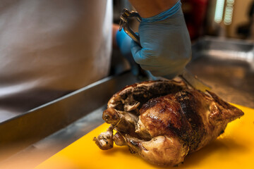 Chef preparing a freshly roasted chicken in the grill of a restaurant