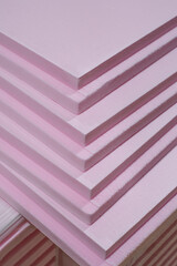 Pink Extruded Polystyrene XPS foam thermal insulation boards stacked in the construction site. High...