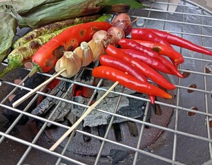 Grilling peppers, onions with the stove as ingredients for making chili paste