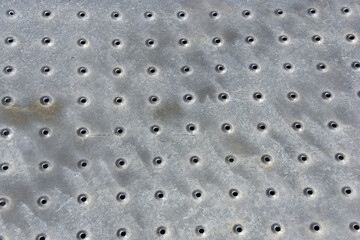 Real perforated stainless metal sheet in construction. Metal mesh with round holes