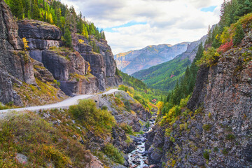 Dangerous dirt road in the mountains near edge with gorge and large cliffs