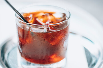 Cold brew with full of ice and black straw on a white background. Delicious cold beverage with coffee.