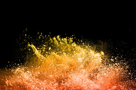 Freeze Motion Of Yellow Dust Explosion Isolated On Black Background.