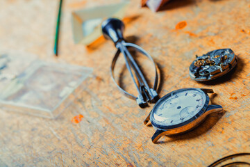 Wristwatch and loose mechanism lying on a watchmakers bench