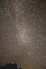 Obraz premium the milky way star cluster and another galaxy in the night sky over Kunisaki, Oita, Japan
