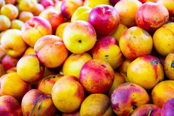 View of harvest of ripe fresh nectarines on counter in food market