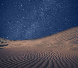 Scenic view of sandy desert under starry sky in night