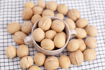 A lot of whole walnuts in a cup on a napkin closeup. Healthy, organic and healthy food with a high content of protein and protein.