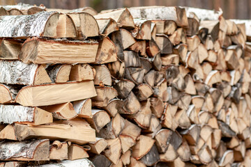 firewood background of chopped wood for kindling and heating the house Close-up. a woodpile with stacked firewood. the texture of the birch tree. banner