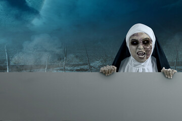 Scary devil nun holding an empty board with night scene background