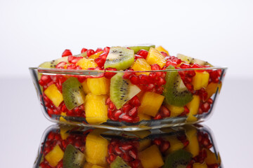 Mixed cut fruits arranged in a transparent tableware , isolated.