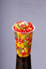 Mixed cut fruits arranged in a transparent tableware , isolated.