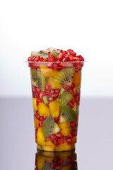Mixed cut fruits arranged in a transparent tableware , isolated.