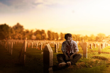 Scary zombie with blood and wound on his body sitting